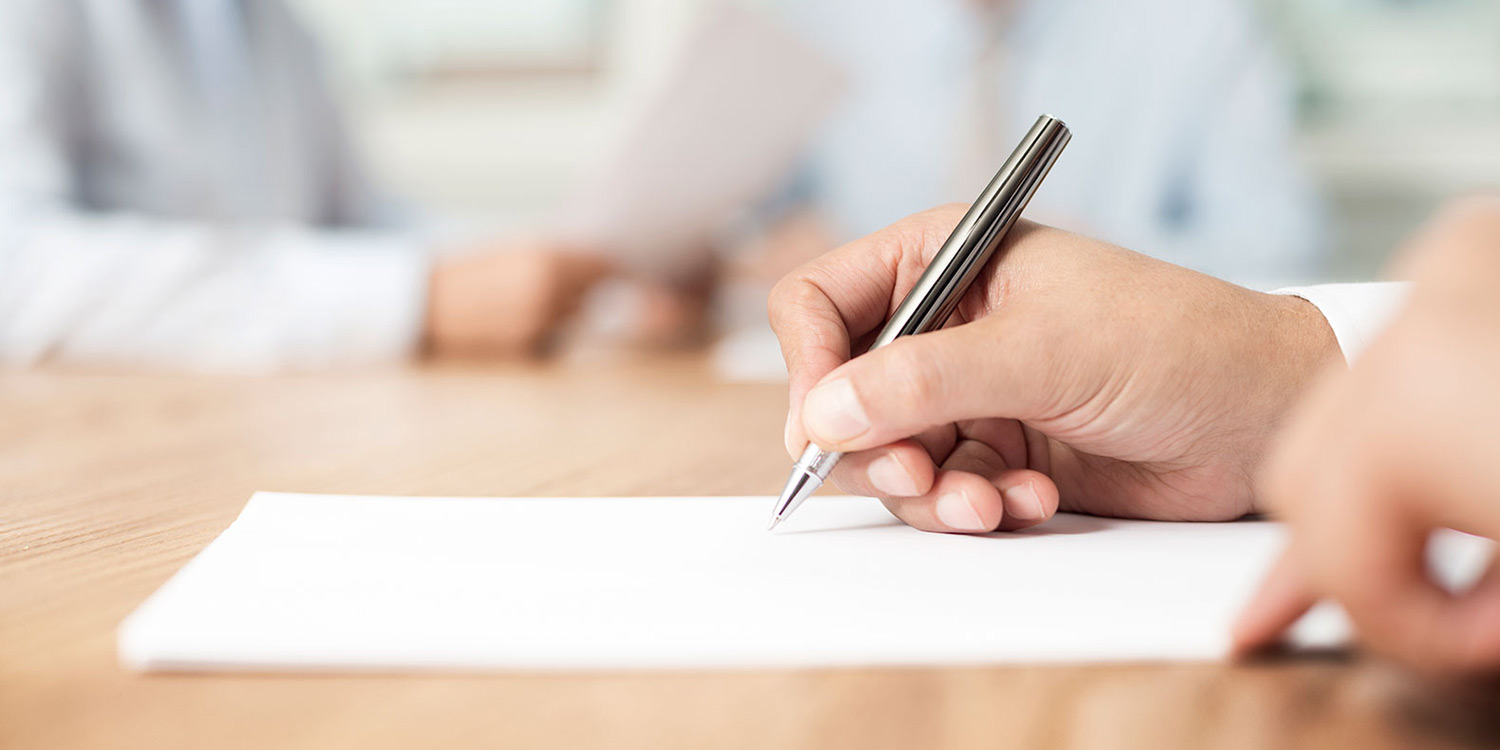 Photo of a hand holding a pen to write